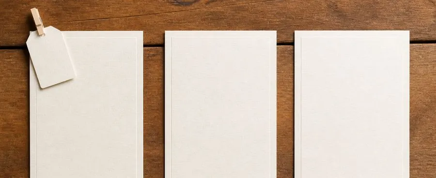 Three blank invitation cards side by side, only one with a price tag attached, representing which price is confirmed.