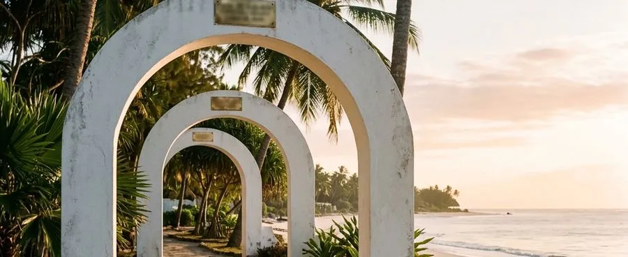 Three similar whitewashed resort entrance archways in a row along a beachfront path at sunrise.