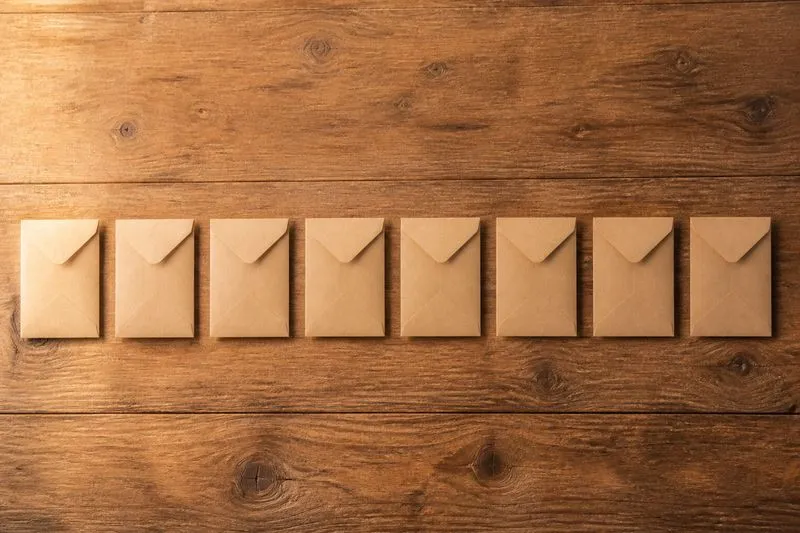 Eight small envelopes arranged in a row, representing the eight stages of wedding planning in sequence.