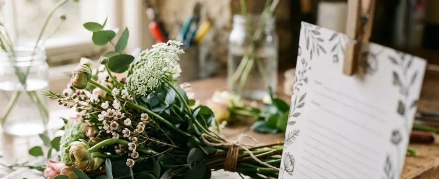 Close-up of a florist's order ticket clipped to a workbench beside floral shears, representing a wire-service delivery order.