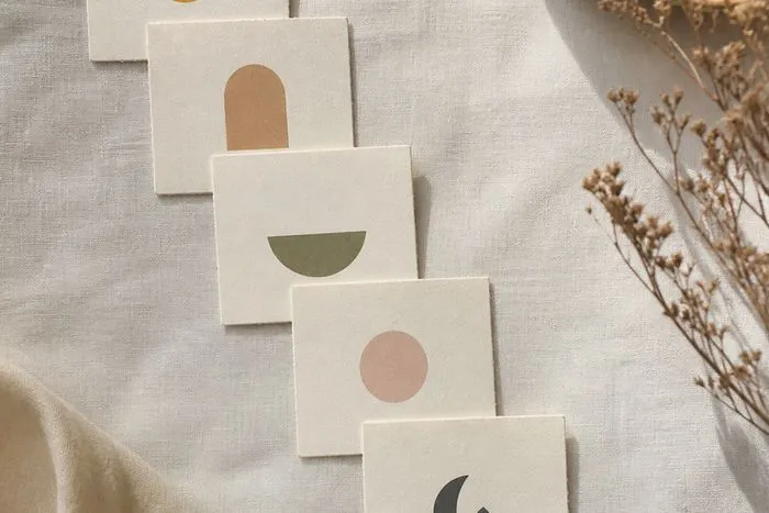 Six small cards laid out in a descending sequence on linen with a pencil resting across the lower cards.